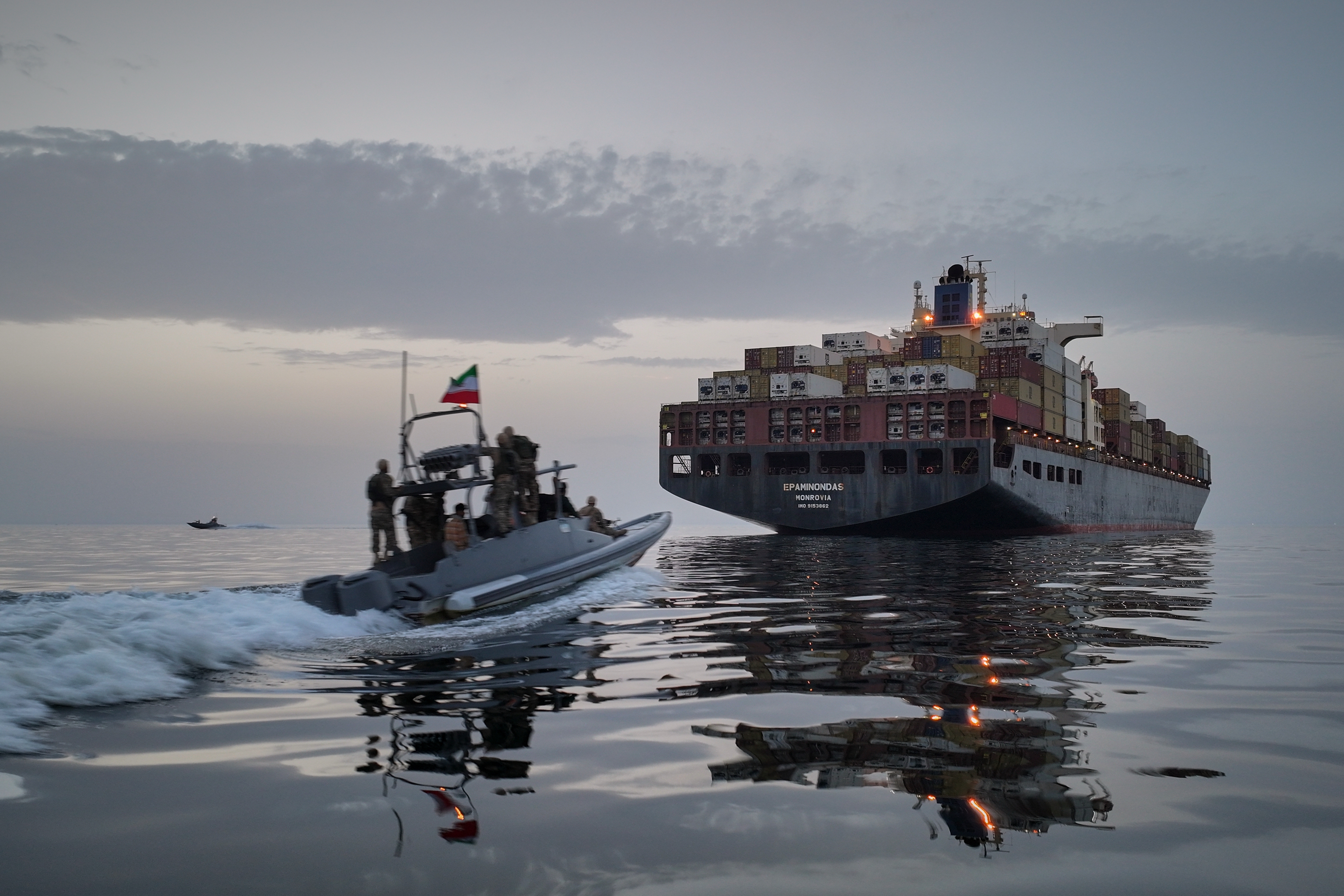 A Revolutionary Guard Navy (IRGC) speedboat approaches the cargo ship Epaminondas during what state media described as the seizure of one of two vessels accused of violations in the Strait of Hormuz, April 21, 2026.